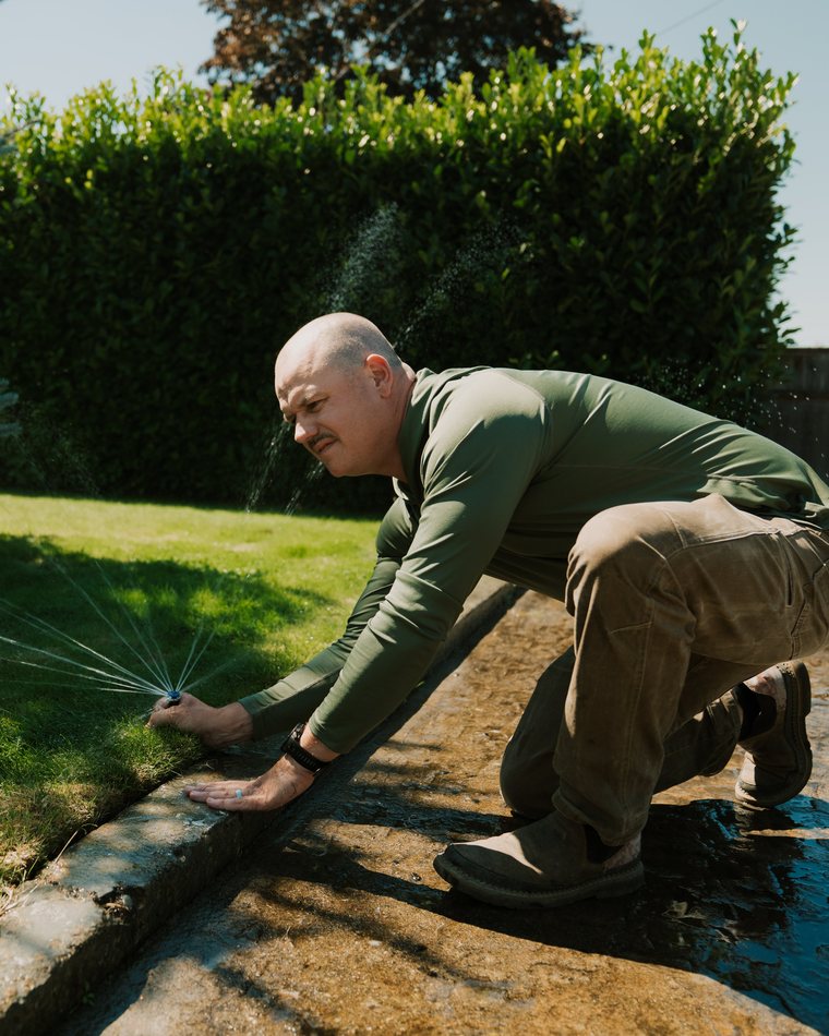 Jeff Hallenbeck adjusting a sprinkler head during a system check